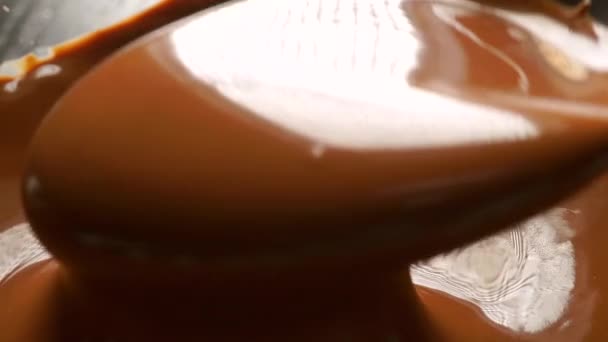 Mengen en gieten van gesmolten chocolade met lepel. Macro slow motion-video — Stockvideo