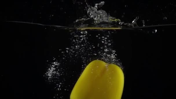 Yellow bell pepper immersing in water, super slow motion video — Stockvideo