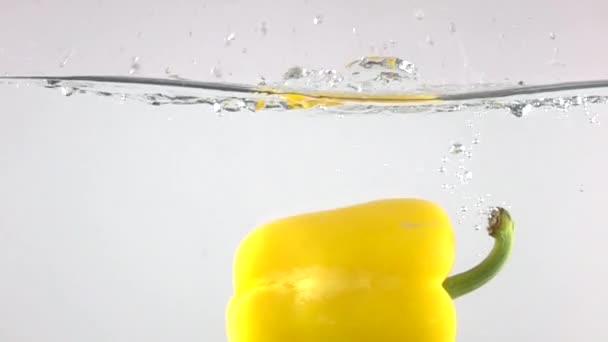 Super slow motion skott av gul paprika faller ner i vatten — Stockvideo