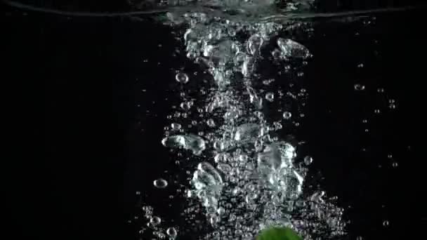 Три зелених огірки падають у воду, супер повільний постріл — стокове відео