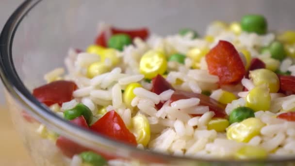 Mistura brilhante de arroz, milho, ervilhas e pimenta vermelha doce em tigela de vidro, 4K dolly shot — Vídeo de Stock