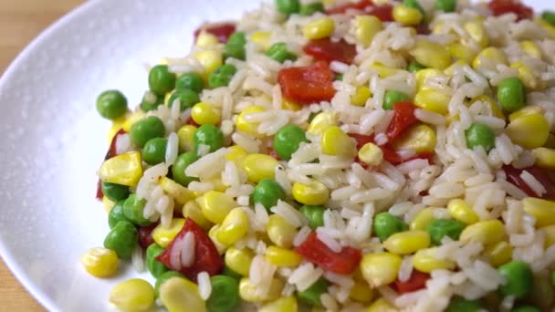 Montón de arroz, maíz, guisantes y pimiento dulce rojo en el plato, 4K dolly shot — Vídeos de Stock