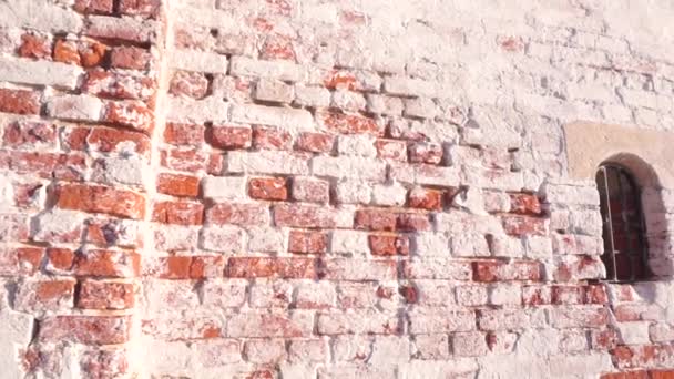 Pequena janela barrada na antiga muralha da fortaleza. Dia ensolarado pan e zoom em tiro — Vídeo de Stock