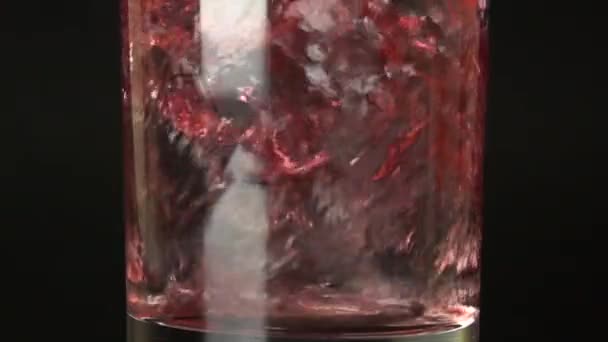 Κοντινό πλάνο του 500 fps αργή κίνηση κόκκινο χυμό που χύνεται σε ένα ποτήρι — Αρχείο Βίντεο