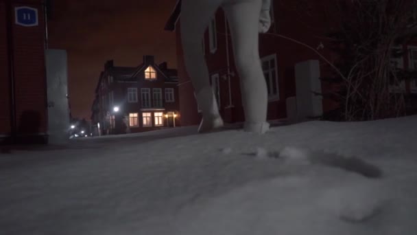 Femme marchant dans les flots de neige le soir — Video