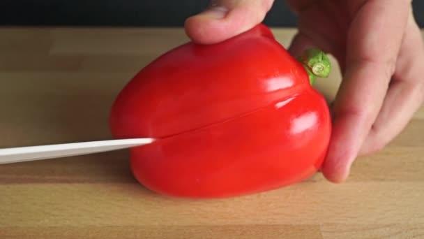 Homme mains coupant poivron rouge entier — Video