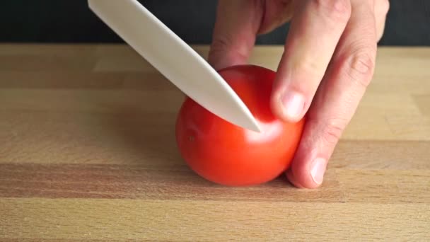 Ερασιτεχνικό κουζίνα σε φέτες ντομάτα κόκκινο στο μπαμπού κοπή του σκάφους — Αρχείο Βίντεο