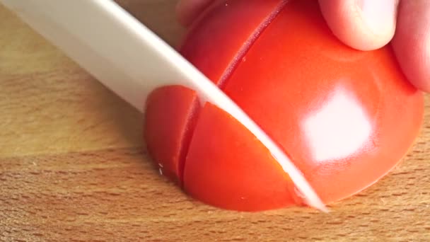 Macro vidéo : homme coupant la moitié de la tomate mûre rouge — Video