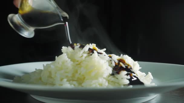 Pouring soy sauce on steaming plain rice, slow motion shot — Stock Video