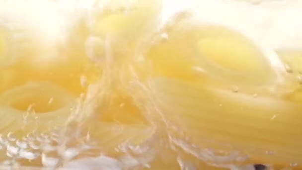 Penne de pasta hirviendo en una sartén de vidrio. Macro dolly video — Vídeo de stock