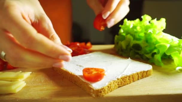 Делаю сэндвич: кладу помидоры черри на хлеб — стоковое видео