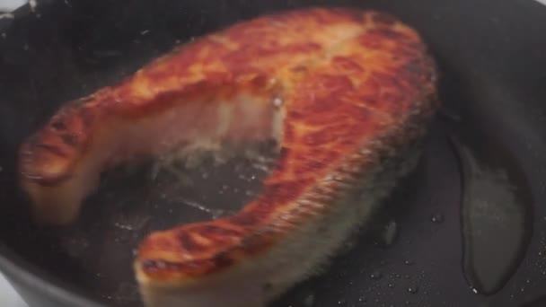 Turning over crusty salmon steak on a frying pan — Stock Video