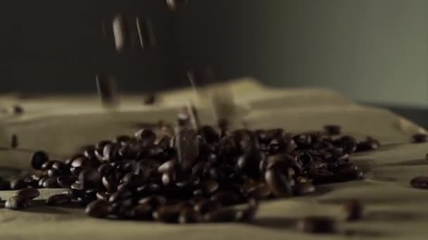 Stéká kávová zrna na hnědém papíře, slow motion video — Stock video