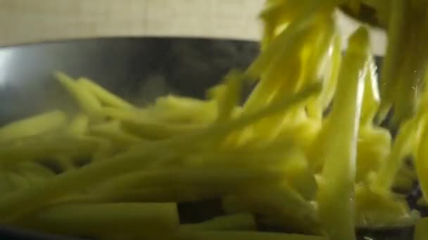 Vaření francouzské hranolky. Zpomalený pohyb kousků brambor padají na pánev — Stock video