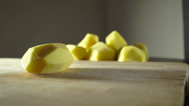 Розрізання цілої очищеної картоплі ножем — стокове відео