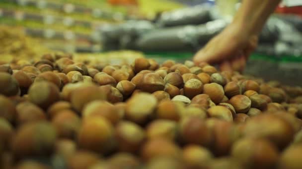 Výběrem některé lískové ořechy s kopečkem v supermarketu — Stock video