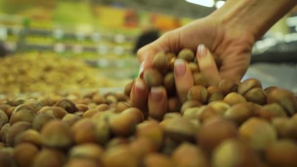 Handjevol hazelnoten in een supermarkt, slow-motion video — Stockvideo