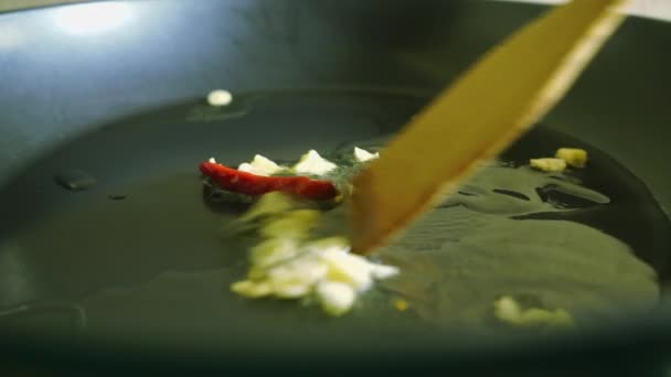 Roosteren, knoflook en rode hete chili in olie voor de saus — Stockvideo