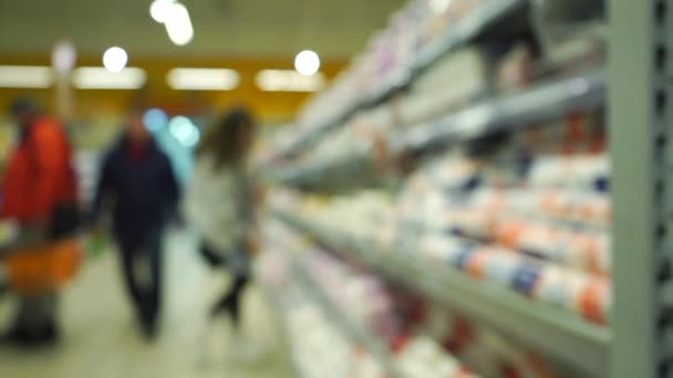 Onherkenbaar jonge vrouw kiest goederen in supermarkt. Bokeh slowmotion video — Stockvideo