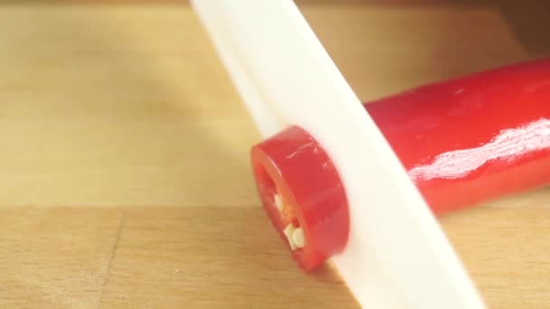 Cortar chile rojo picante en una tabla de cortar de madera ligera. Vídeo macro — Vídeos de Stock
