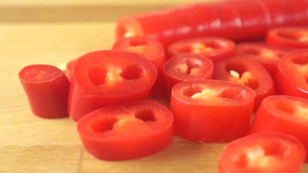 Trozos de chile rojo picante en la tabla de cortar. Macro dolly tiro — Vídeos de Stock