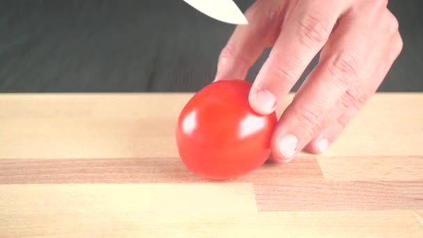 Découpe de tomates rouges entières avec couteau en céramique — Video