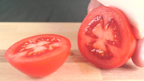 Cortar tomate rojo maduro en una tabla de cortar de madera — Vídeo de stock