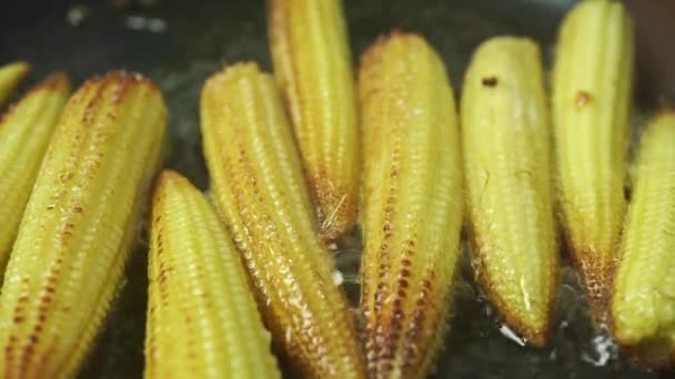 Close up shot of roasting small corn cobs — Stock Video