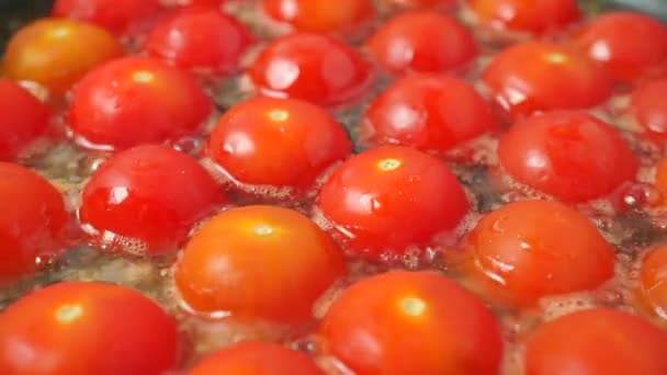 Piros cseresznye paradicsom zár megjelöl szemcsésedik sütés — Stock videók