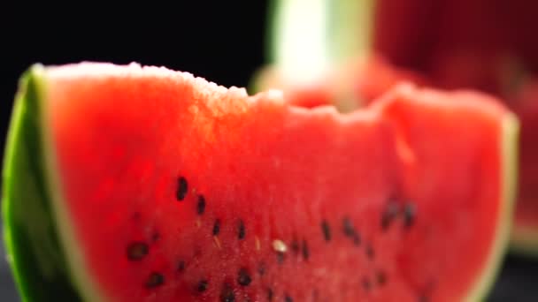 Saftige Wassermelonenscheiben vor dunklem Hintergrund — Stockvideo