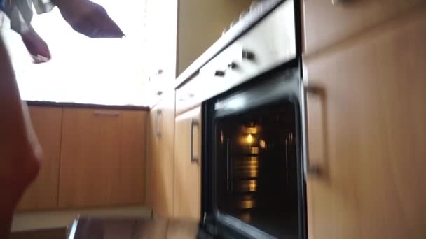 Een bakplaat in een oven geplaatst — Stockvideo