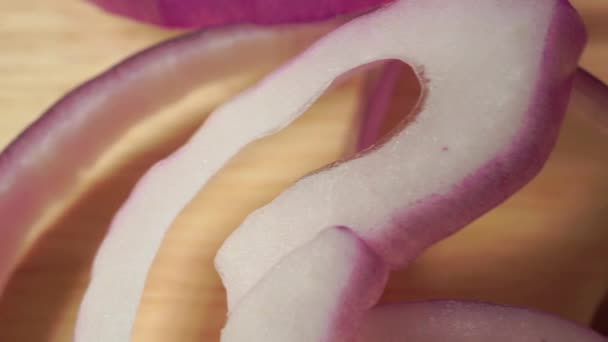 Red onion rings on a wooden cutting board, close up — Stock Video