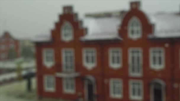 Slow motion video of snowflakes in front on red brick town house — Stock Video