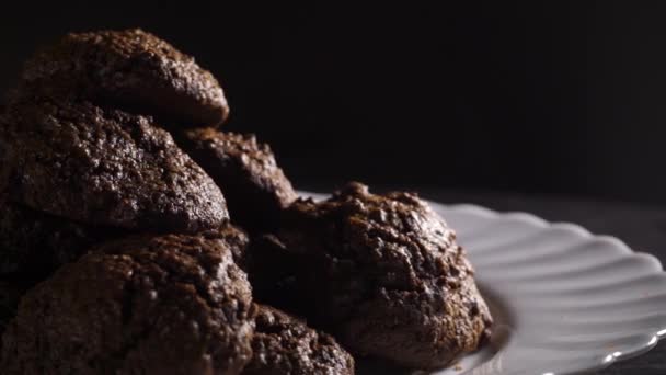 Drehteller mit hausgemachten Schokoladenkeksen auf schwarzem Hintergrund — Stockvideo