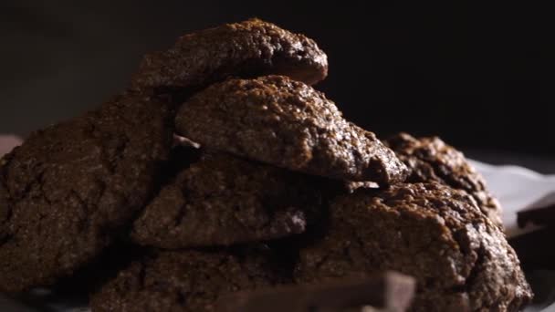 Rotating plate with homemade chocolate cookies on black background — Stock Video
