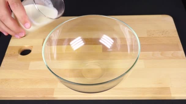 Derramando leite em uma tigela de vidro, vídeo em câmera lenta — Vídeo de Stock