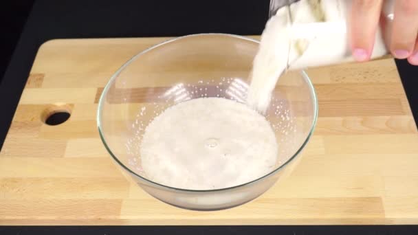 Mettre la farine dans le lait dans un bol en verre — Video