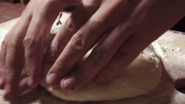 Мужчина руками кладет тесто на деревянную доску — стоковое видео