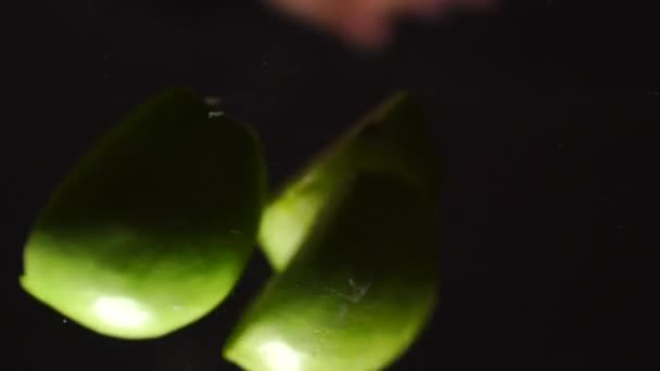 Зеленое яблоко падает на камеру и расщепляется. Видео замедленного действия — стоковое видео