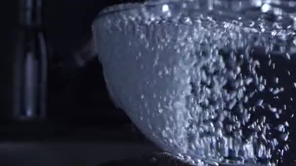 Agua del grifo de agua que desborda un recipiente de vidrio, video en cámara lenta — Vídeo de stock