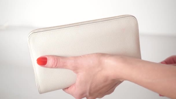 Chica con esmalte de uñas rojo abriendo su bolso blanco vacío — Vídeos de Stock