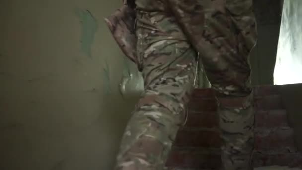 Camuflaje con soldado colándose en un edificio en ruinas hostil — Vídeo de stock