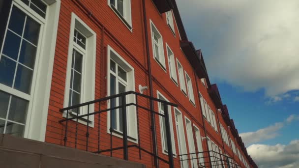 Clouds floating above row of red brick townhouses — Stock Video