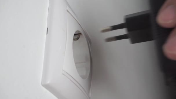 Turning on off the black adapter into a wall socket rapid — Stock Video