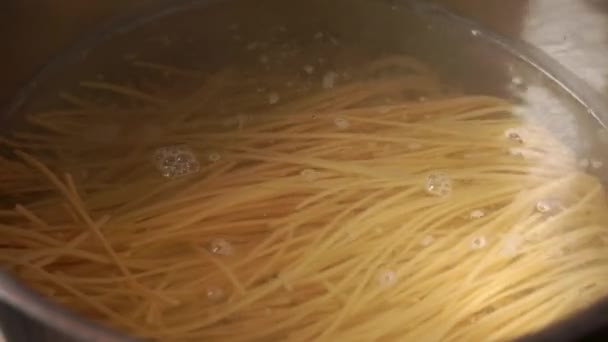 Spaghetti brengen in een pan kokend water — Stockvideo