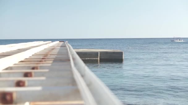Schwimmendes Boot weit weg von der Seebrücke — Stockvideo