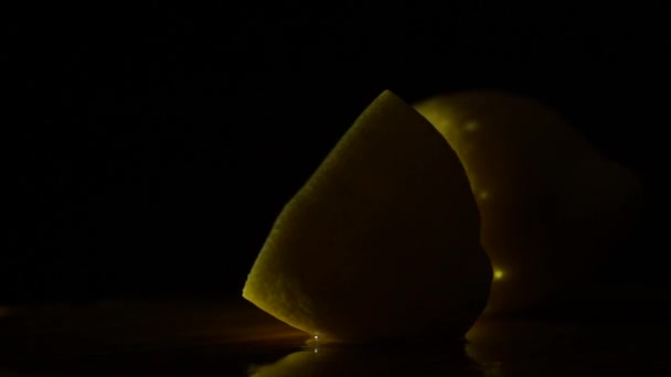 Juicy lemon on a platter on a black background — Stock Video