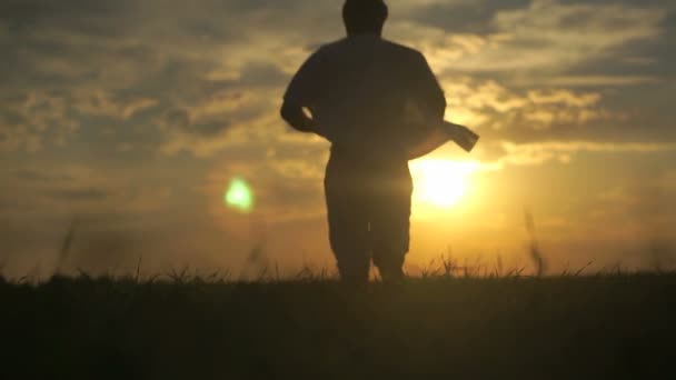Silhouette eines Mannes, der auf den schönen Sonnenuntergang zuläuft — Stockvideo