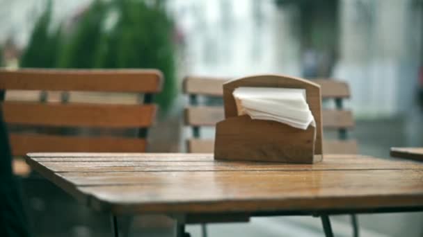 Garçom no café de rua ao ar livre limpando a mesa após o início da chuva — Vídeo de Stock