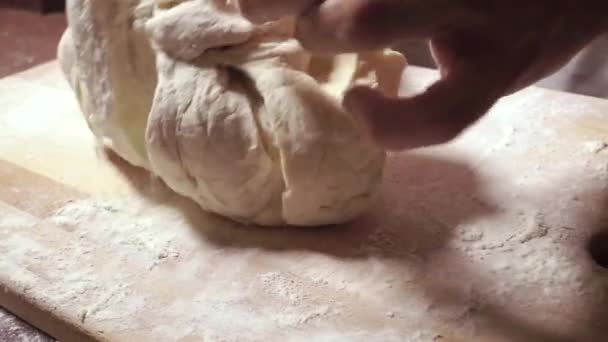 Young man hands kneadding dough on wooden cutting board — Stock Video